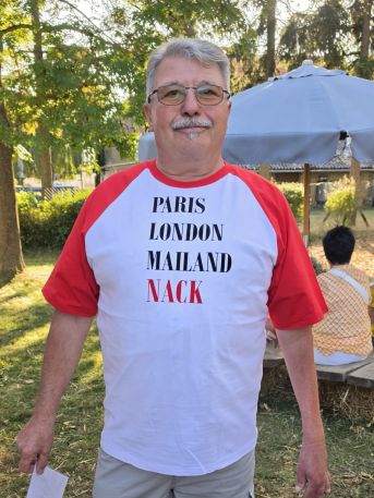 Ein Mann mit einem T-Shirt auf dem Paris, London, Mailand und Nack aufgelistet sind